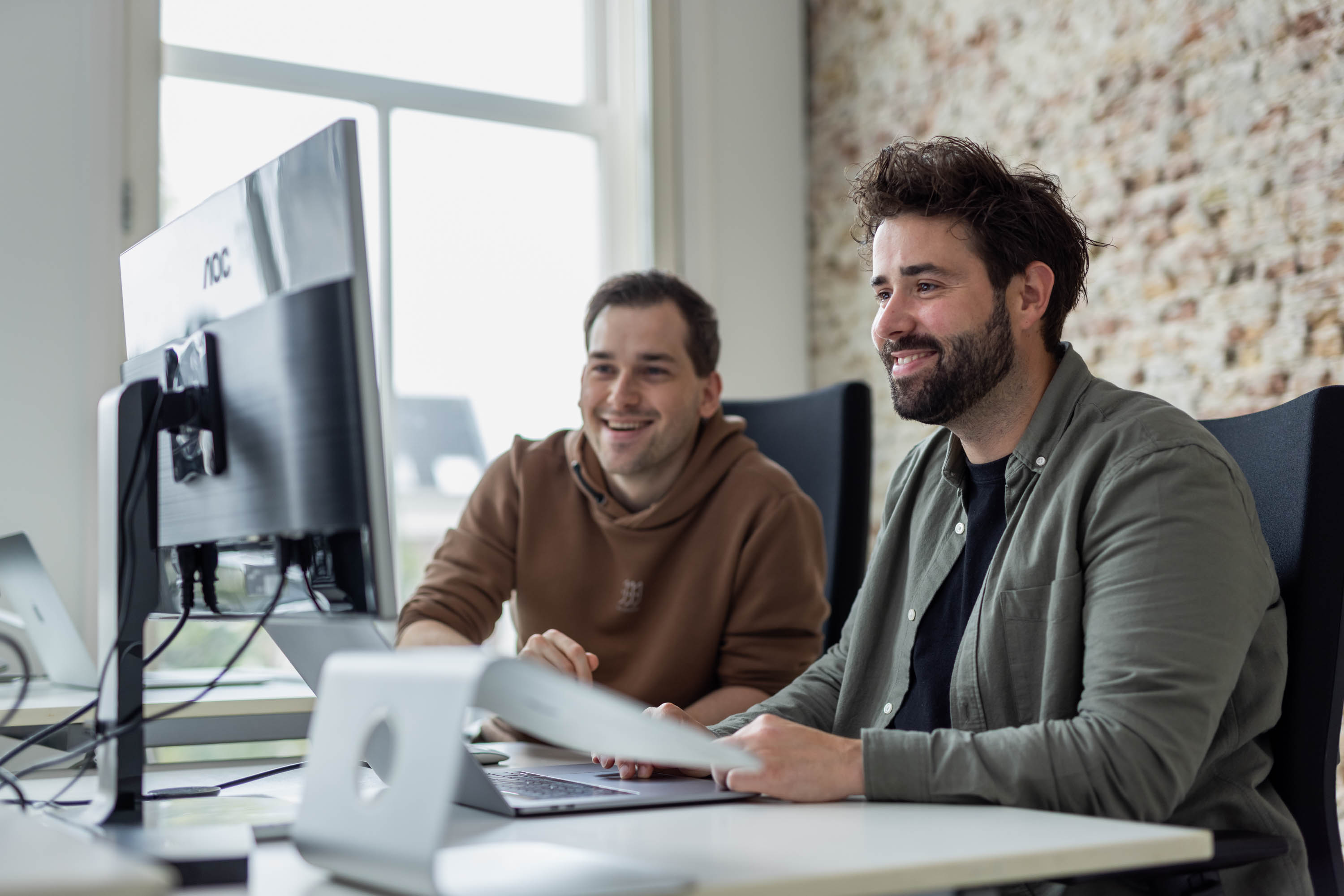 Twee collega's overleggen over digitale strategie.
