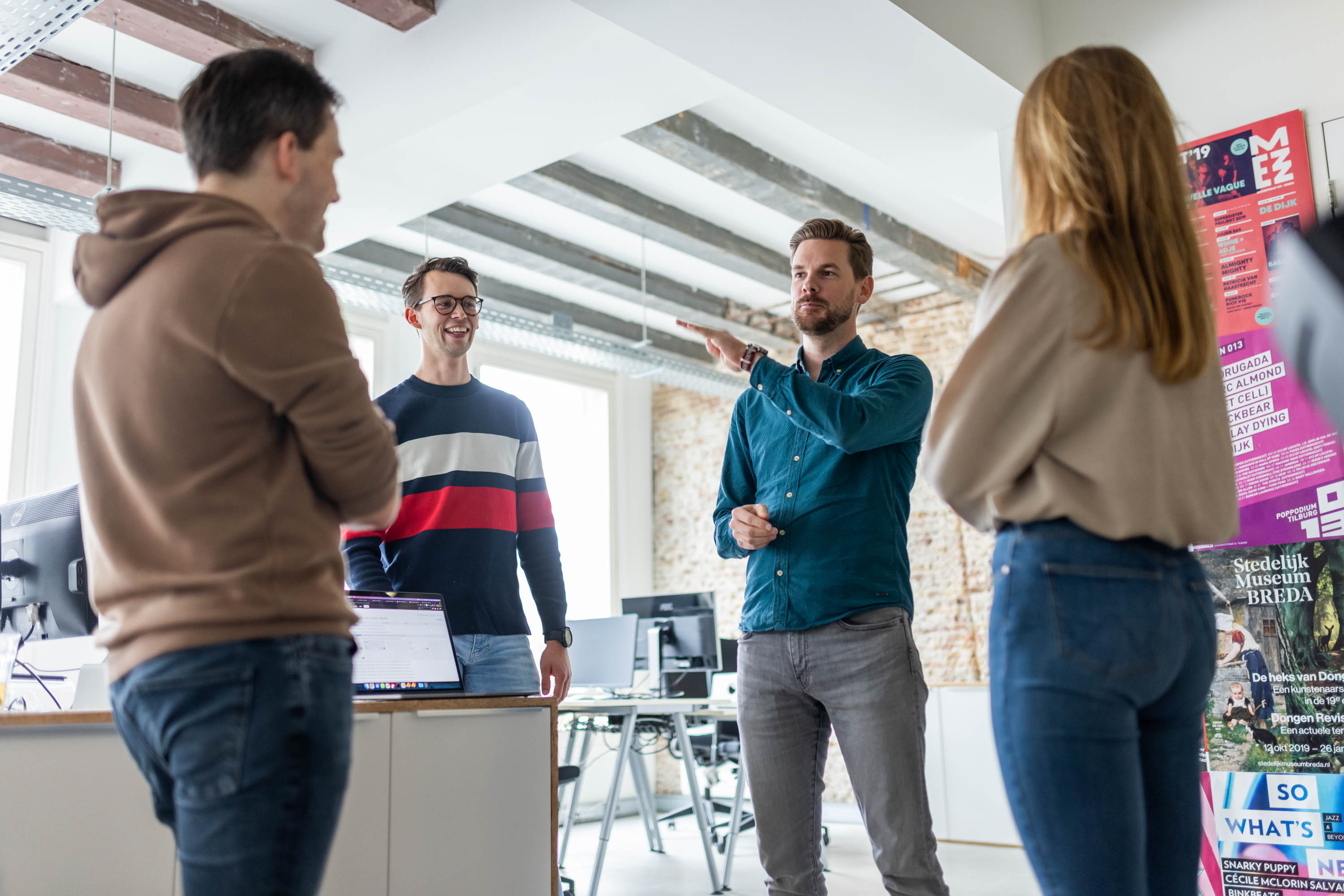 Vier collega's bespreken een bericht op het intranet bij Netvlies