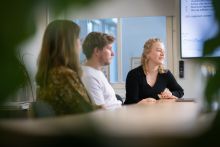 Kelly in overleg met collega's.